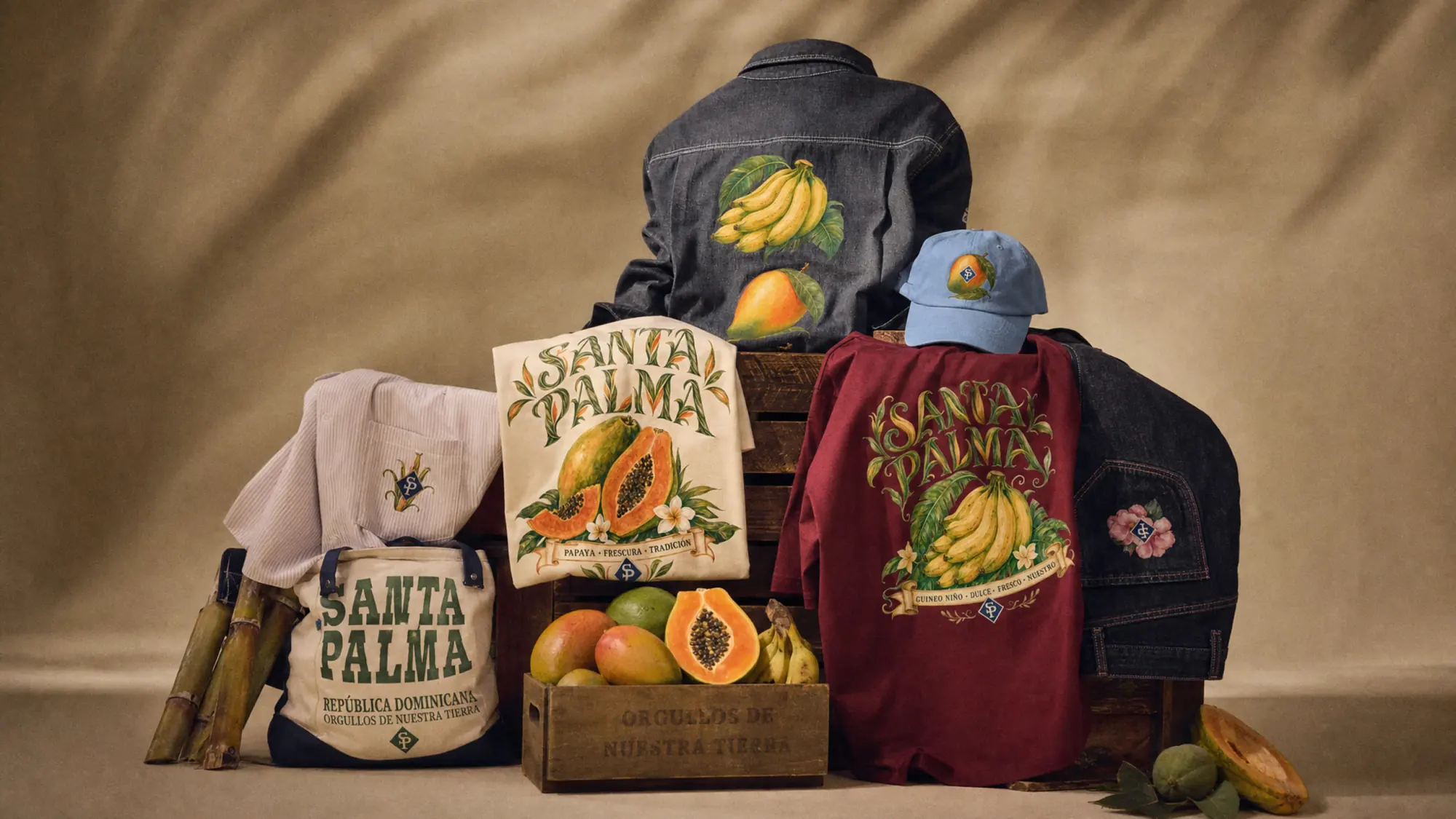 Bodegón de estudio: chaqueta vaquera, bolsos de lona, cajón de fruta, camiseta vino, gorra y caña cortada